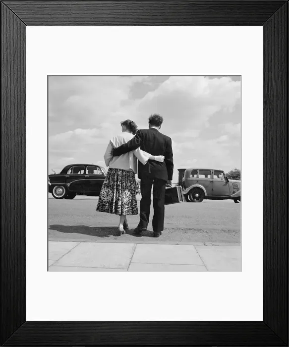 Framed Print : Young couple standing with arms around each other Framed Print : Young couple standing with arms around each other