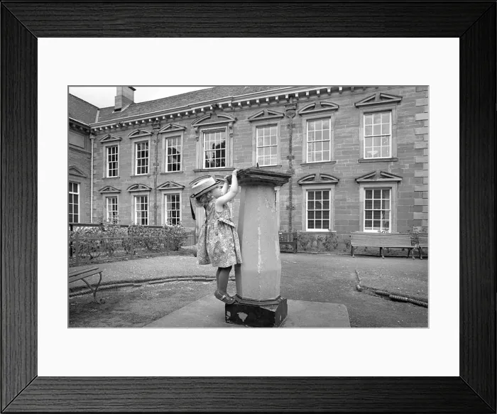 Framed Print : Girl climbing on a sundial outside Tulle House Museum Framed Print : Girl climbing on a sundial outside Tulle House Museum