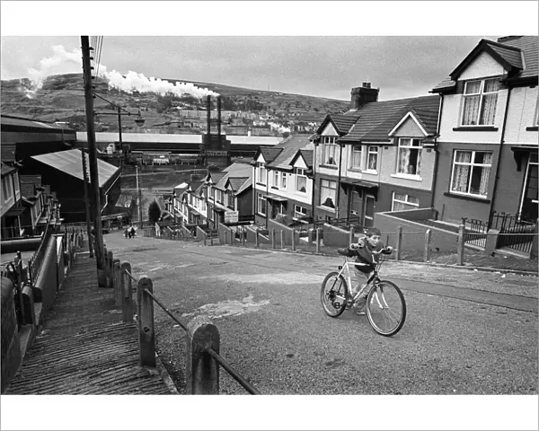Boy pushes his bicycle up a hill in Ebbw Vale, South Wales