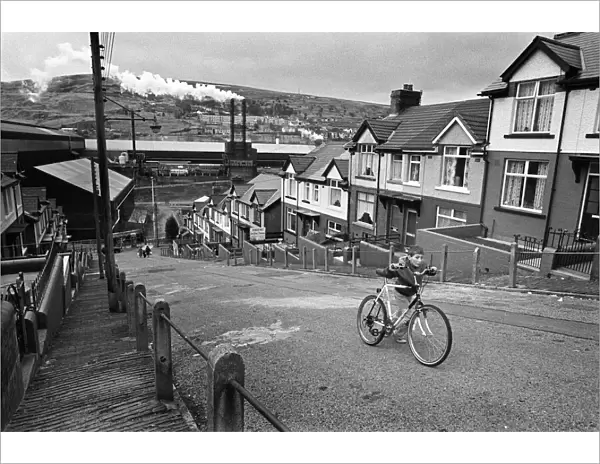 Boy pushes his bicycle up a hill in Ebbw Vale, South Wales