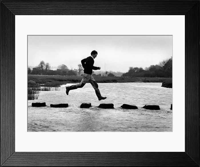 Framed Print : A man leaps along the stepping stones at Ogmore Castle Framed Print : A man leaps along the stepping stones at Ogmore Castle