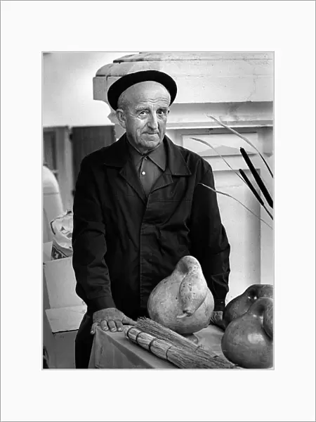 Frenchman with large gourd in a market in Montaigu-de-Quercy