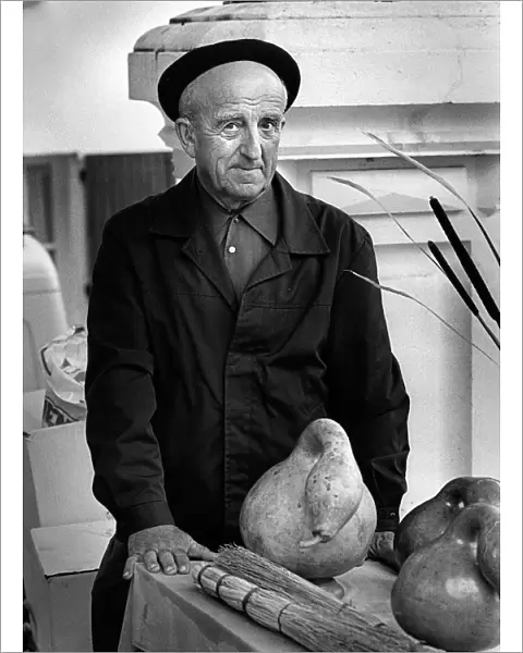 Frenchman with large gourd in a market in Montaigu-de-Quercy