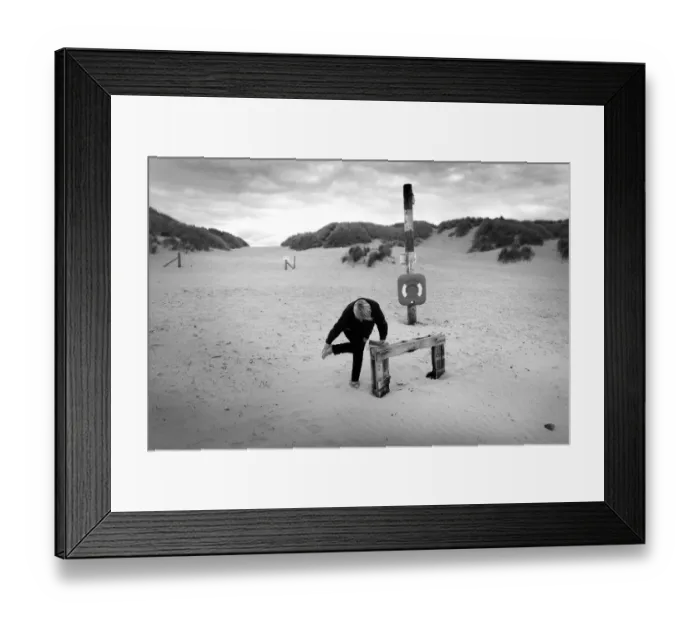 Framed Print : Woman bends over to brush sand from her feet, Harlech beach Framed Print : Woman bends over to brush sand from her feet, Harlech beach