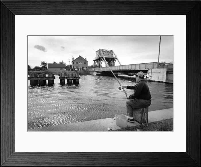 Framed Print : A fisherman sits on the towpath of the Caen Canal