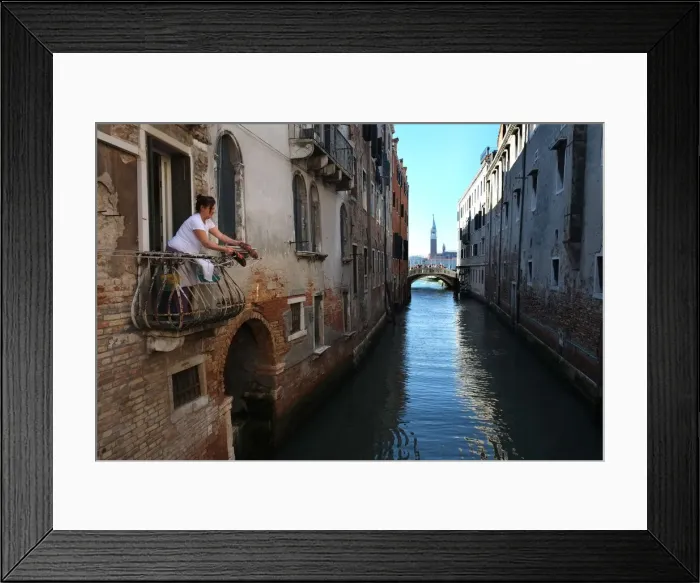 Framed Print : Woman shakes the dirt off a pair of trainers, Venice Framed Print : Woman shakes the dirt off a pair of trainers, Venice