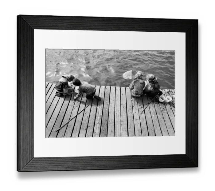 Framed Print : Children fishing for crabs on wooden pontoon, New Brighton