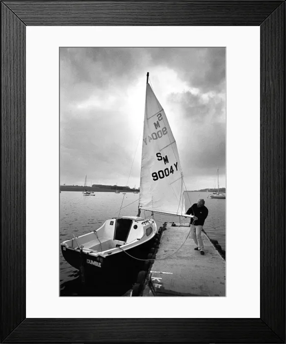 Framed Print : A sailor prepares his small yacht for a sail on Rutland Wate Framed Print : A sailor prepares his small yacht for a sail on Rutland Wate
