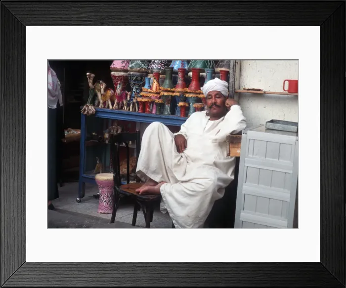 Framed Print : Shopkeeper lounges outside his souvenir shop, Cairo, Egypt Framed Print : Shopkeeper lounges outside his souvenir shop, Cairo, Egypt