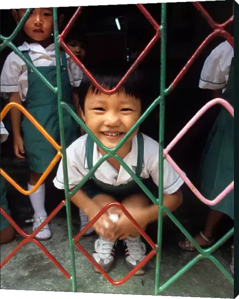 A small child behind the grill of a kindergarten, Hong Kong