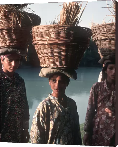 Kashmiri women wearing Kashmiri shirts with baskets of reeds