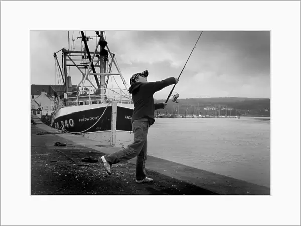 Boy casts his fishing line into River Dee at Kirkcudbright
