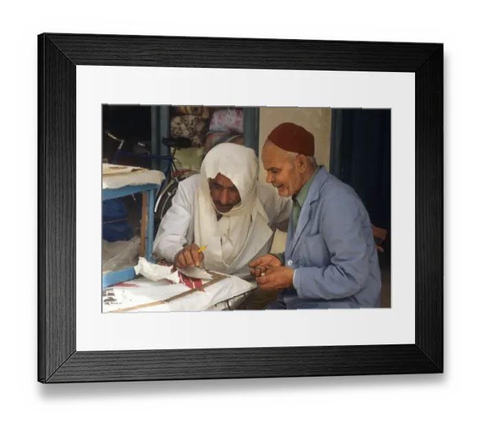 Framed Print : Two men sit beside stall in the market at Houmt Souk, Djerba Framed Print : Two men sit beside stall in the market at Houmt Souk, Djerba