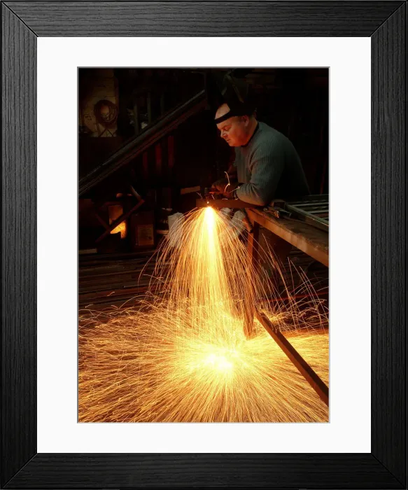Framed Print : A steelworker makes a shower of sparks in his workshop Framed Print : A steelworker makes a shower of sparks in his workshop