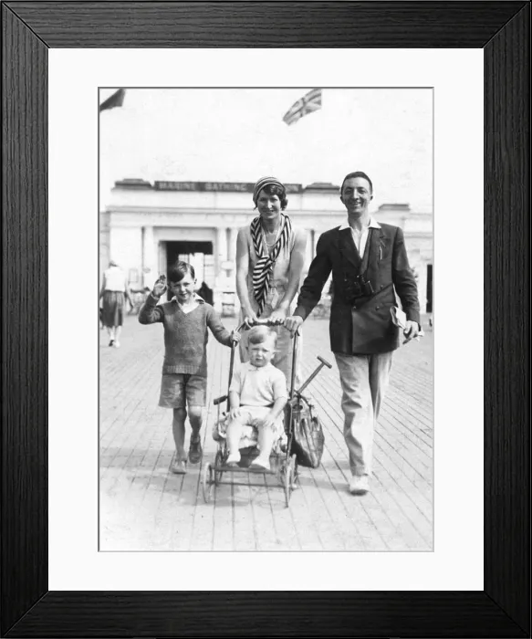 Framed Print : Family enjoying a holiday walk on a seaside promenade Framed Print : Family enjoying a holiday walk on a seaside promenade
