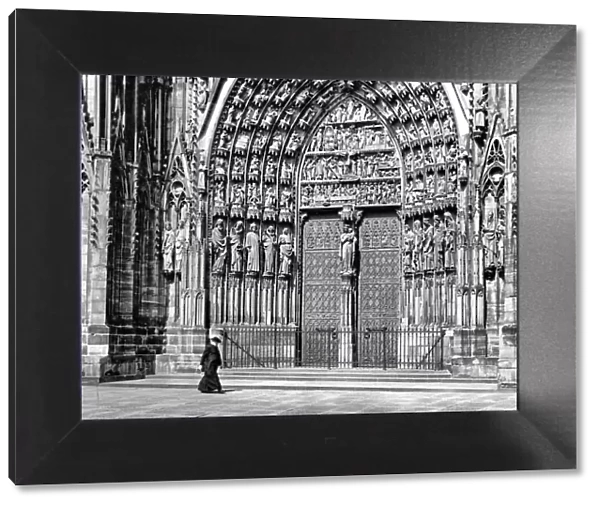 Priest walking in front of Strasbourg Cathedral, France