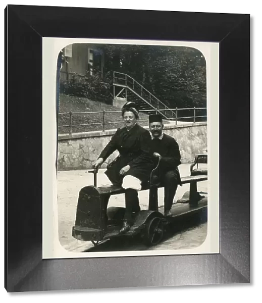 A German couple on a fun miniature railway ride, possibly at the seaside