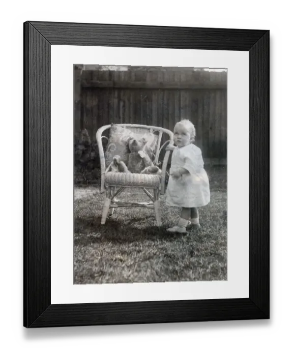 Framed Print : A baby toddles up to an elegant cane chair in her garden to say hello to her favourite Framed Print : A baby toddles up to an elegant cane chair in her garden to say hello to her favourite