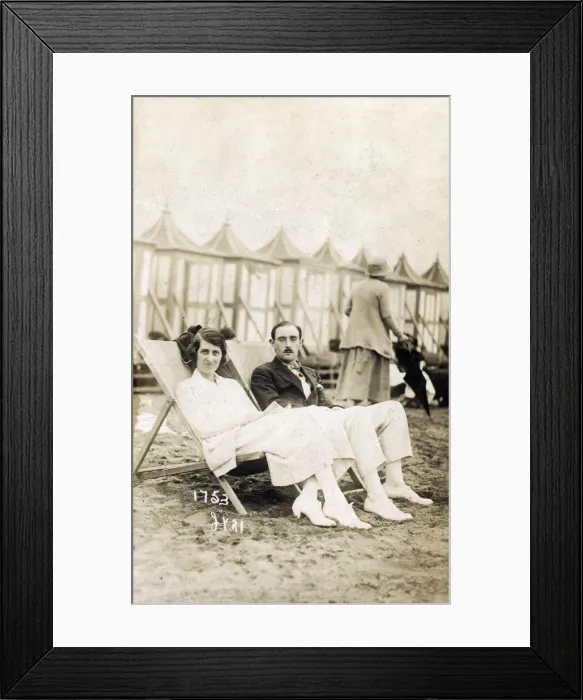 Framed Print : Smart young couple sat on the beach in deckchairs Framed Print : Smart young couple sat on the beach in deckchairs