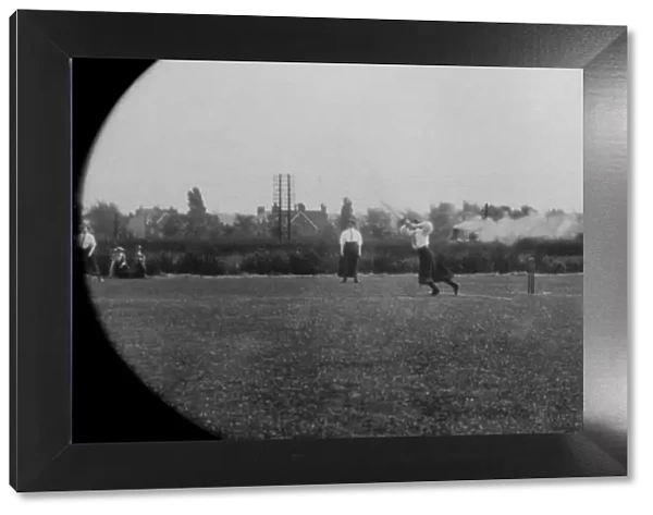 Students playing cricket steam train in background