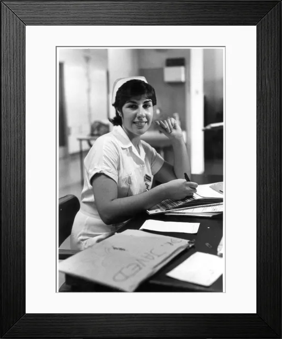 Framed Print : Nurse seated at desk Framed Print : Nurse seated at desk