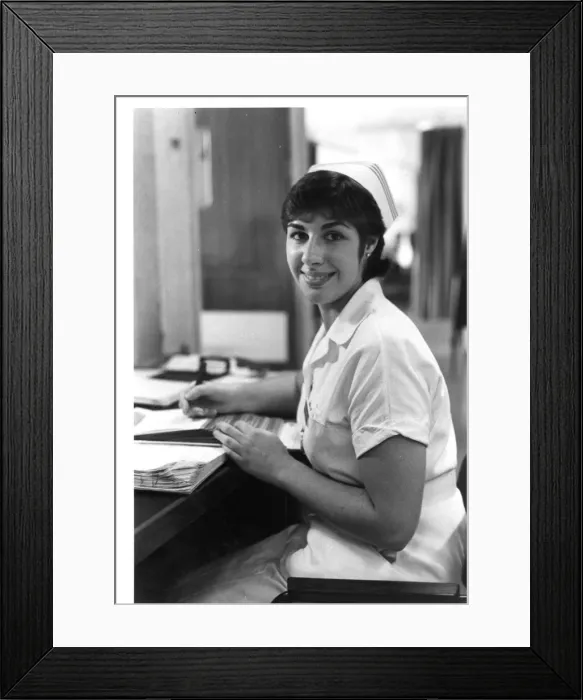 Framed Print : Nurse seated at desk Framed Print : Nurse seated at desk