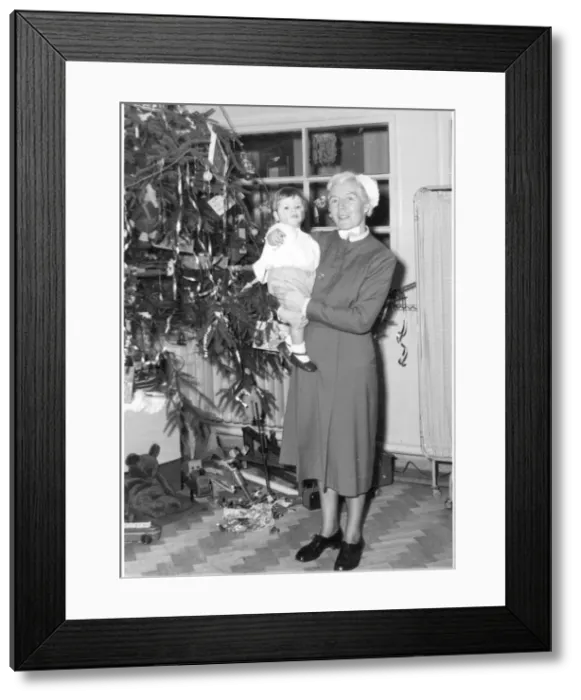 Framed Print : Nurse holding child next to Christmas tree Framed Print : Nurse holding child next to Christmas tree