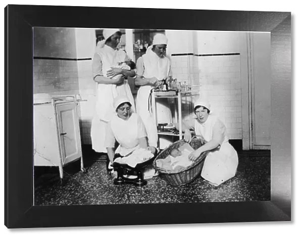 Nurses weighing babies