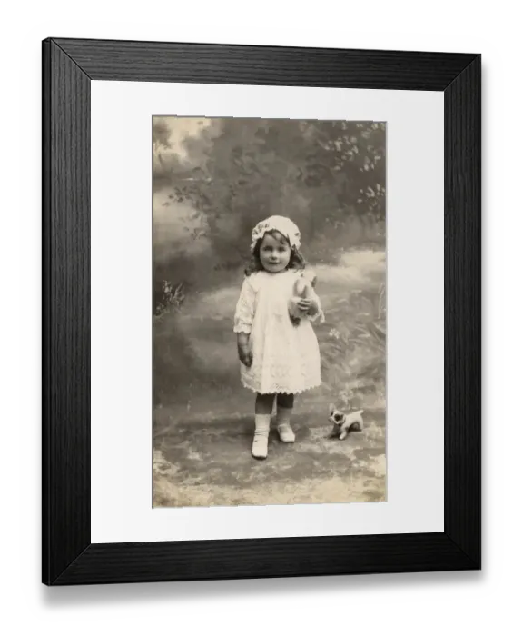 Framed Print : A little girl in lacy dress and cap poses with a toy bulldog Date: circa 1915 Framed Print : A little girl in lacy dress and cap poses with a toy bulldog Date: circa 1915