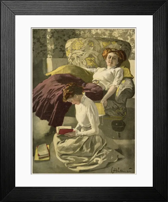 Framed Print : Two girls reading books, one sprawled in an armchair, the other kneels on the floor Framed Print : Two girls reading books, one sprawled in an armchair, the other kneels on the floor