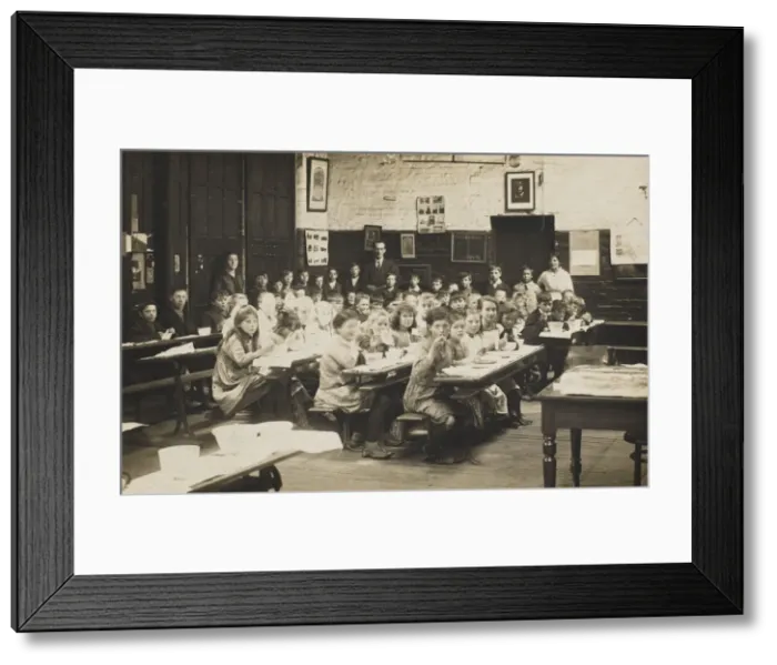 Framed Print : Schoolchildren ear their midday meal at their desks. Date: early 20th century Framed Print : Schoolchildren ear their midday meal at their desks. Date: early 20th century