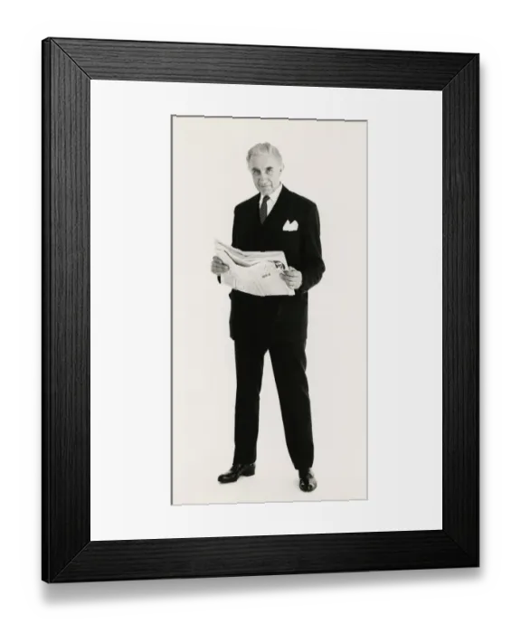 Framed Print : Full length portrait of a mature man posing in a suit, holding a newspaper Framed Print : Full length portrait of a mature man posing in a suit, holding a newspaper