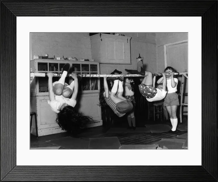 Framed Print : Children hanging from a pole, doing excercises during a gym class. Date: 1960s Framed Print : Children hanging from a pole, doing excercises during a gym class. Date: 1960s