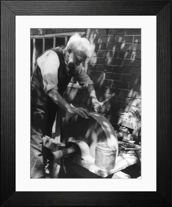 Framed Print : The village farrier (blacksmith) sharpening a pair of garden shears at his wheel Framed Print : The village farrier (blacksmith) sharpening a pair of garden shears at his wheel