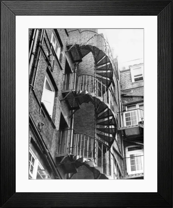 Framed Print : An iron spiral staircase, probably used as a fire escape. Date: 1950s Framed Print : An iron spiral staircase, probably used as a fire escape. Date: 1950s