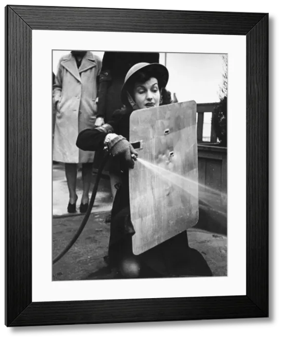 Framed Print : West End stage and film star, Miss Judy Campbell, learns how to use a stirrup pump Framed Print : West End stage and film star, Miss Judy Campbell, learns how to use a stirrup pump