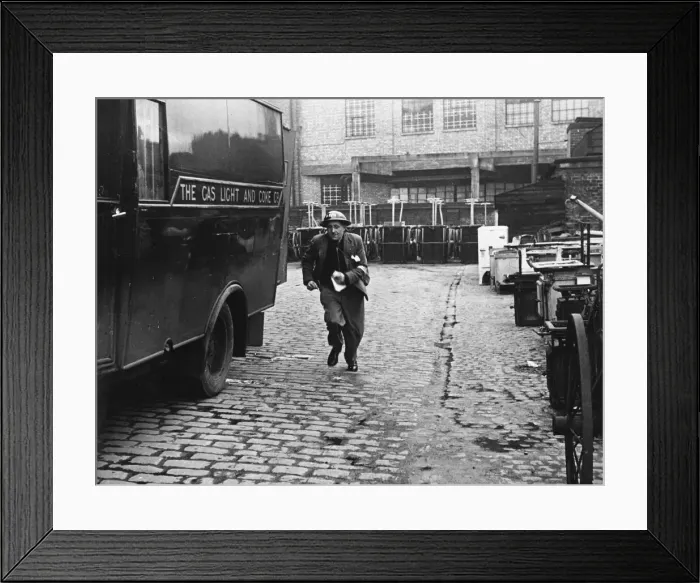Framed Print : A messenger runs with the news that a gas main is on fire after an air raid during World Framed Print : A messenger runs with the news that a gas main is on fire after an air raid during World