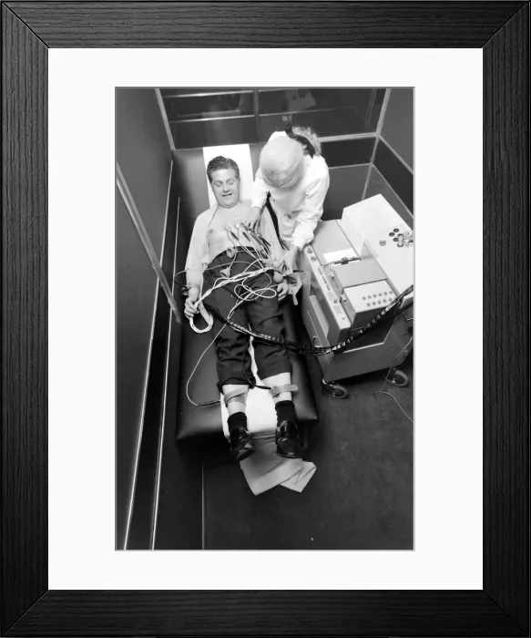 Framed Print : Biomedical centre, London -- a woman attaches sensors to a patient. Date: 1972 Framed Print : Biomedical centre, London -- a woman attaches sensors to a patient. Date: 1972