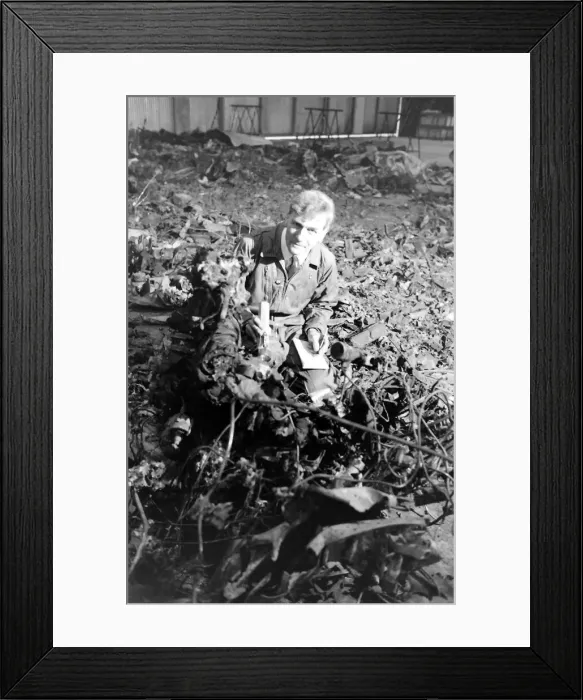 Framed Print : An air crash investigator at work in an indoor location with pieces of wreckage from a Framed Print : An air crash investigator at work in an indoor location with pieces of wreckage from a