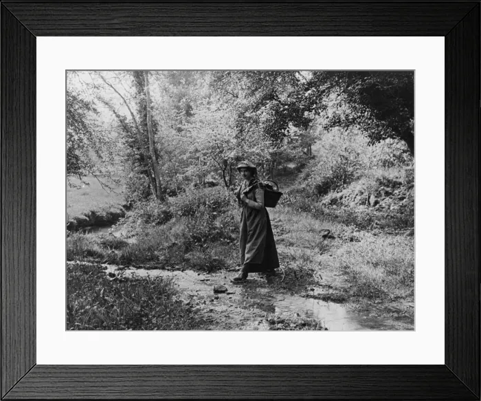 Framed Print : Woman crossing a brook, 1890s Framed Print : Woman crossing a brook, 1890s