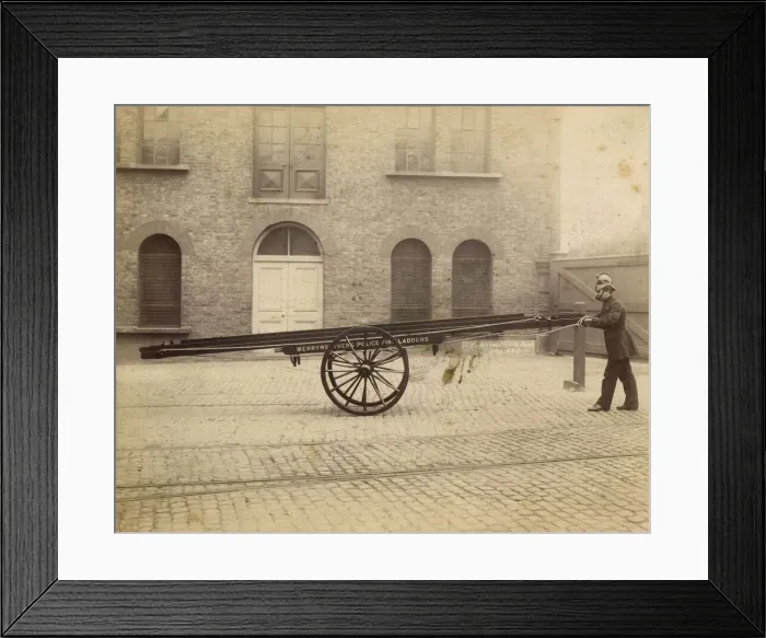 Framed Print : A firefighter with a Merryweather wheeled ladder escape Framed Print : A firefighter with a Merryweather wheeled ladder escape
