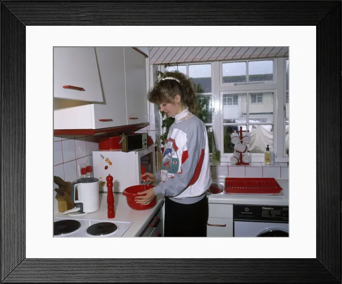 Framed Print : Young woman cooking in a kitchen Framed Print : Young woman cooking in a kitchen