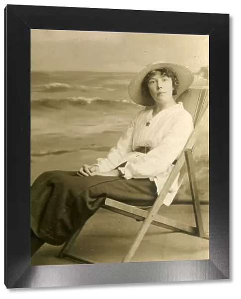 Young woman in a deckchair in a studio photo
