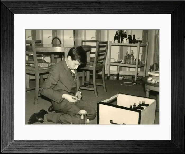 Framed Print : Boy kneeling on the floor sorting out some glass jars Framed Print : Boy kneeling on the floor sorting out some glass jars
