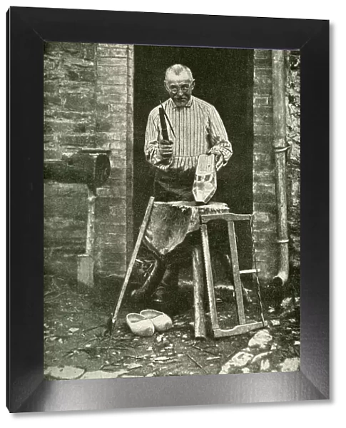 Sabot maker working at his cottage door, Belgium