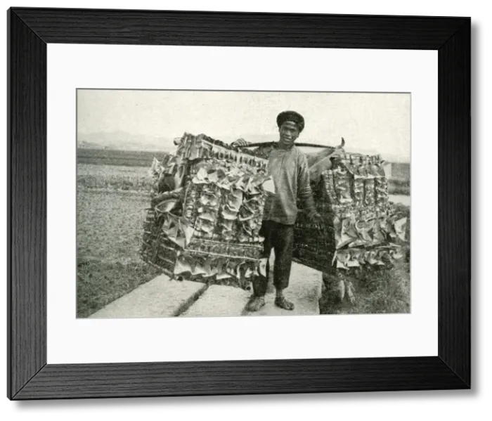 Framed Print : Man carrying imitation paper money, China, East Asia Framed Print : Man carrying imitation paper money, China, East Asia
