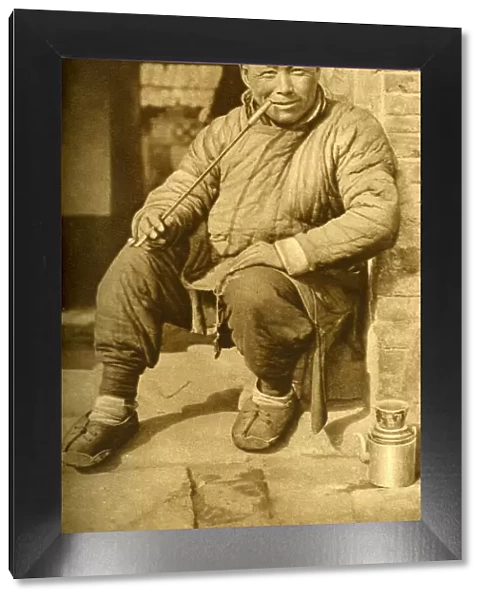 Man relaxing and smoking his pipe, China, East Asia