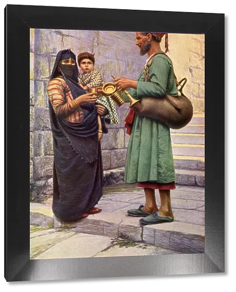 Water carrier handing a drink to a woman, Cairo, Egypt