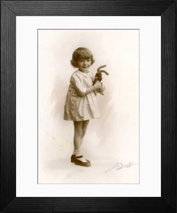 Framed Print : Little girl holds a toy rabbit, circa 1930s Framed Print : Little girl holds a toy rabbit, circa 1930s