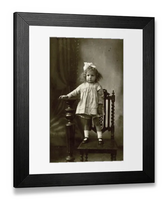 Framed Print : Studio photo of young girl standing on a chair Framed Print : Studio photo of young girl standing on a chair